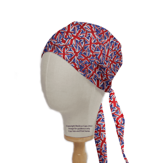 A mannequin head wears a Flag UK Scrub Cap by Medicus Scrub Caps, adorned with vibrant overlapping Union Jack flags. The cap features two long ties at the back and is made from eco-friendly materials for comfort, with a fabric label reading Copyright Medicus Caps 2022.