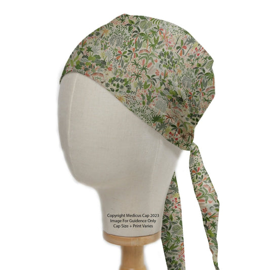 A mannequin head wears the Medicus Scrub Caps Floral Jungle Scrub Cap with green and pink floral patterns and a tie at the back, posed against a white backdrop.