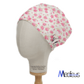 A mannequin head displays the Floral Pink On Ivory Scrub Cap by Medicus Scrub Caps, featuring a pink floral rose design. The logo Medicus Scrub Caps at the bottom right emphasizes their commitment to sustainable healthcare.