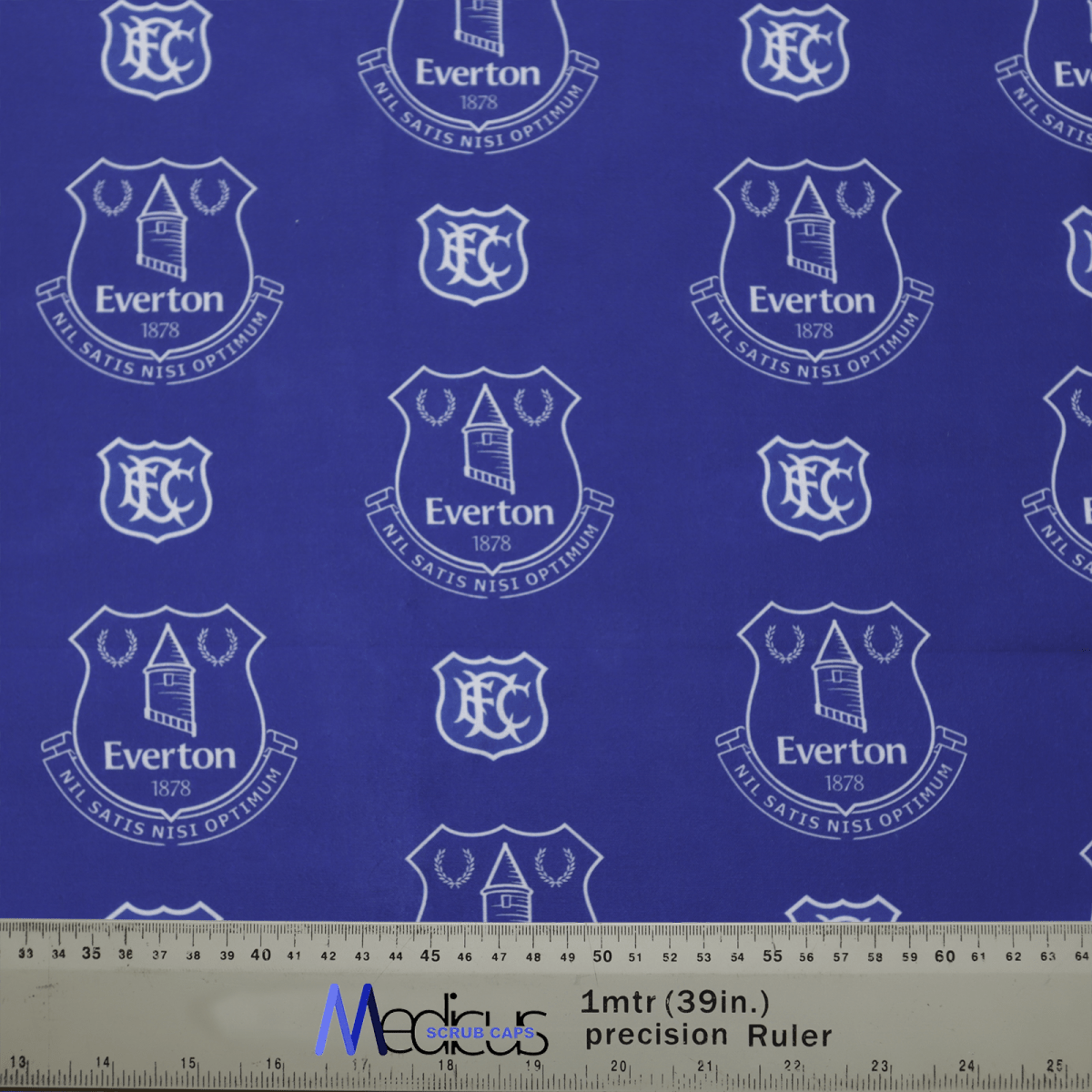 The Football Club Everton Scrub Cap from Medicus Scrub Caps features a blue fabric with white Everton FC crests, EFC, 1878, and a banner. A measuring ruler is visible at the bottom.