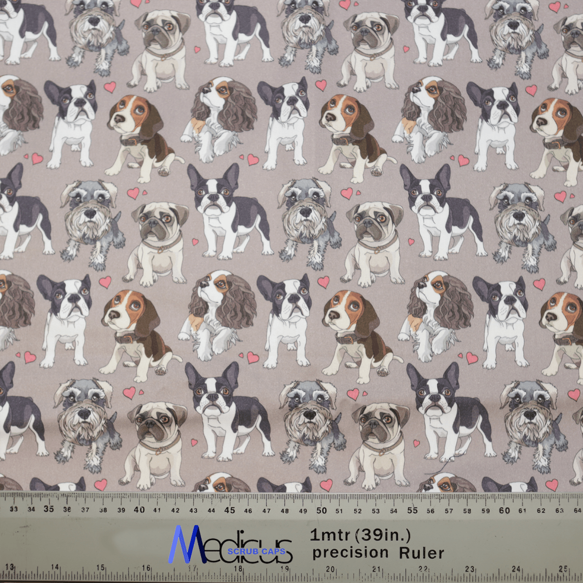 The For The Love Of Dogs Scrub Cap by Medicus Scrub Caps features a charming fabric pattern with cartoon bulldogs, boxers, and spaniels on a light brown background. Small pink hearts add charm, and an included ruler provides measurements in inches and centimeters for inclusive sizing.