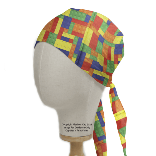 The Medicus Scrub Caps Games Lego Tetris Large Scrub Cap features an eco-friendly design with vibrant interlocking bricks in red, blue, yellow, green, and orange. Adjustable ties at the back ensure a perfect fit, as showcased on a mannequin head.