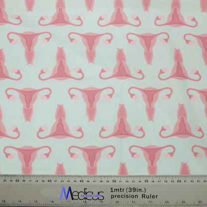 The Gynecology Surgeon Scrub Cap by Medicus Scrub Caps is crafted from handmade fabric with pink uterus designs on a light background. A ruler in meters and inches ensures precision for reusable creations, perfect for unique surgeon scrub caps.