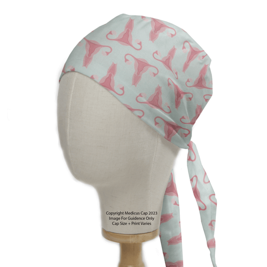 The Medicus Scrub Caps Gynecology Surgeon Scrub Cap is a reusable, handmade surgical cap in light blue with pink uterus designs. It fits securely with a back tie, offering both practicality and style for professionals.