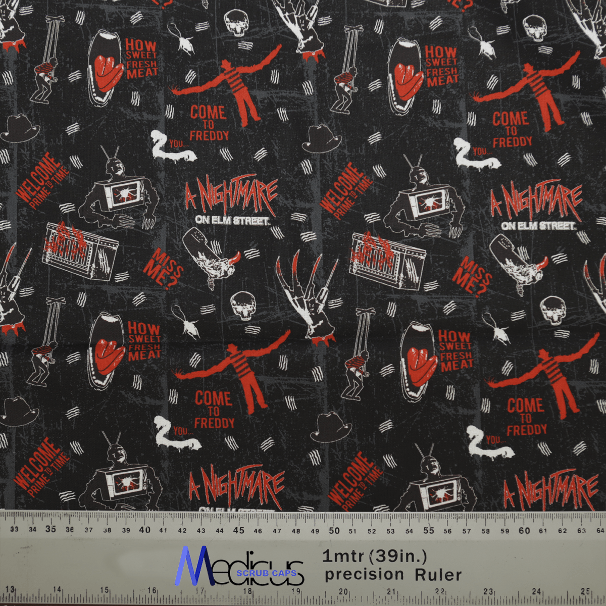 The Halloween Nightmare On Elm St scrub caps by Medicus Scrub Caps feature black fabric with red and white illustrations of Freddy Krueger, gloves, and phrases like How Sweet Fresh Meat, making it ideal for personalized scrub caps. A ruler at the bottom provides metric and inch measurements.