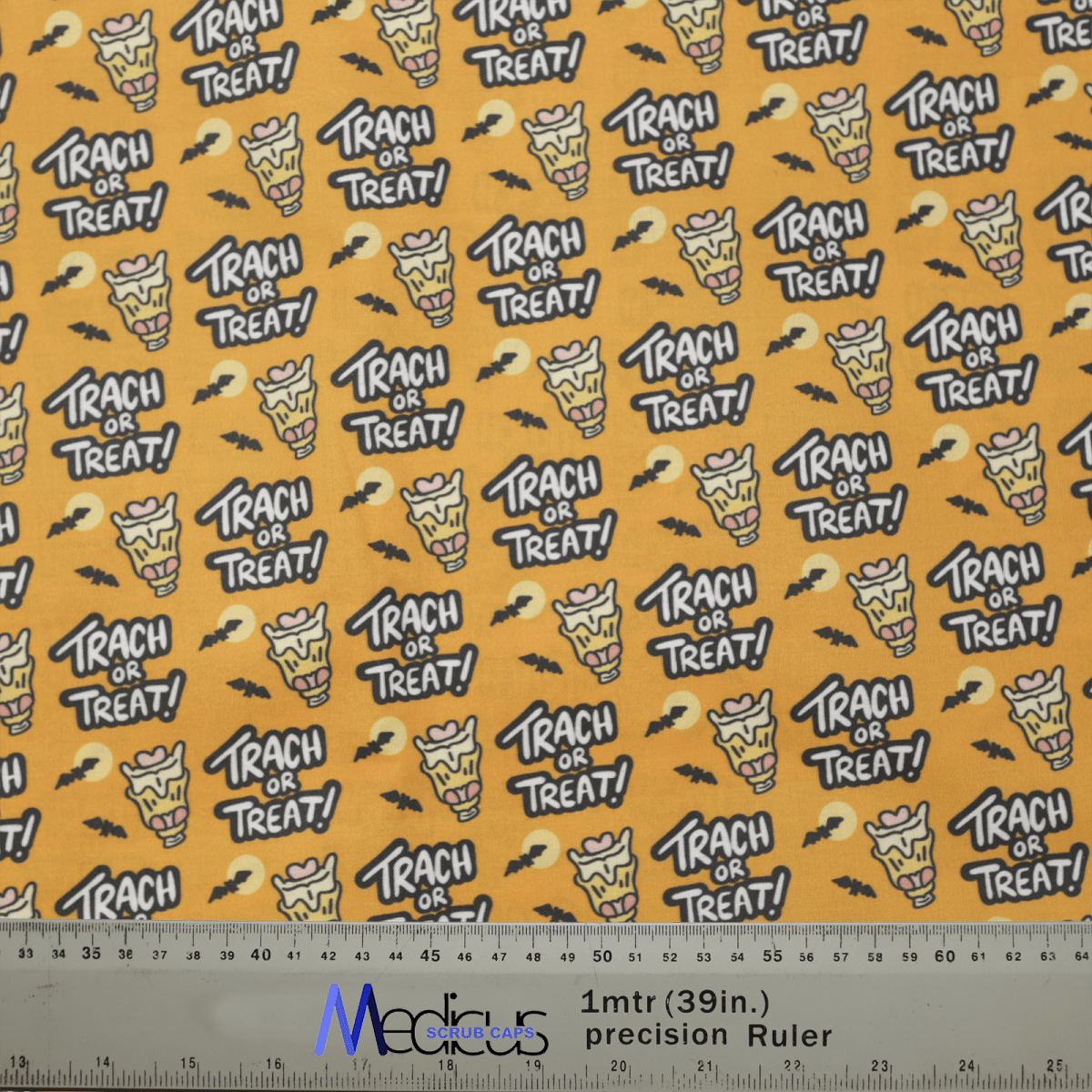 The eco-friendly yellow fabric by Medicus Scrub Caps, featuring cartoon candy corn and TRACH OR TREAT! text in white, is perfect for Halloween scrub caps. A ruler at the bottom provides measurements in inches and centimeters for easy customization. Product Name: Halloween Tract Or Treat Scrub Caps.