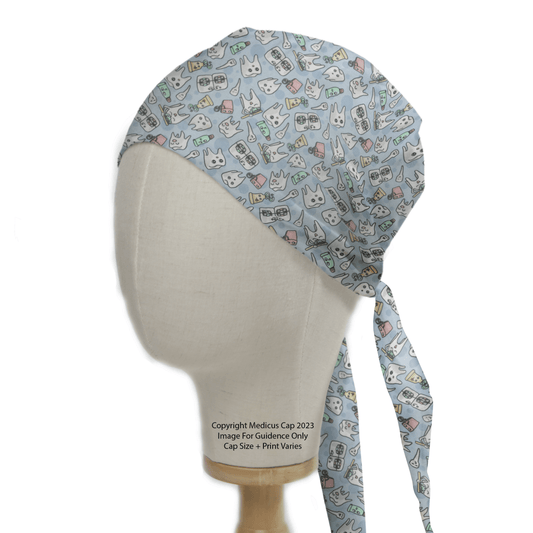 The Medicus Scrub Caps Happy Teeth Braces Scrub Cap, modeled on a mannequin head, features a playful design of cats, dogs, and medical items like stethoscopes and syringes. Set against a white backdrop, it ties at the back for a snug fit.