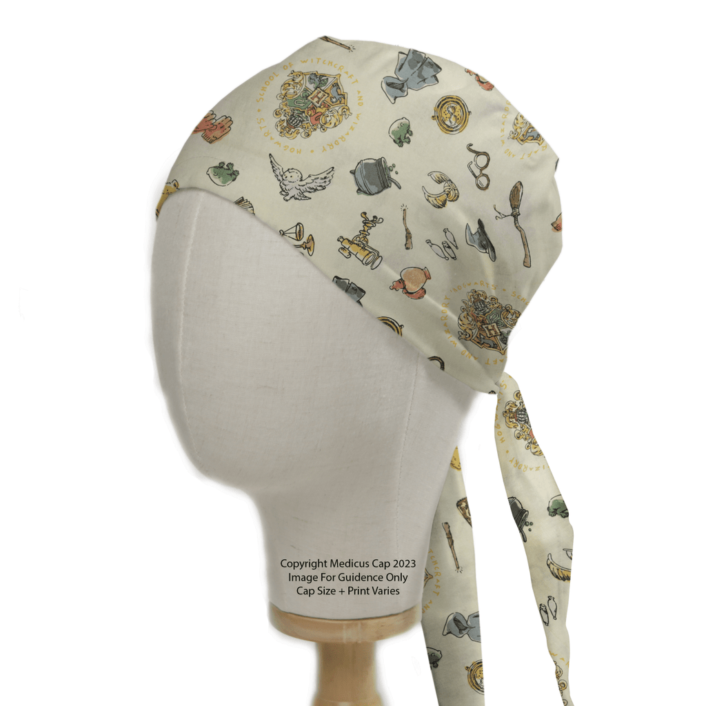 A mannequin head wears a Medicus Scrub Caps eco-friendly scrub cap featuring a Harry Potter-inspired design with crests, cauldrons, wands, and magical accessories on beige fabric.