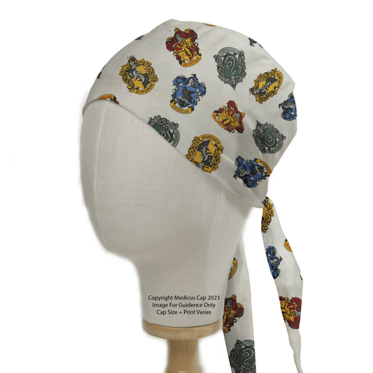 The Harry Potter Houses Scrub Cap by Medicus Scrub Caps features a white design with colorful house crests, ties in the back, and offers a smooth fit, celebrating healthcare heroes with magical style.