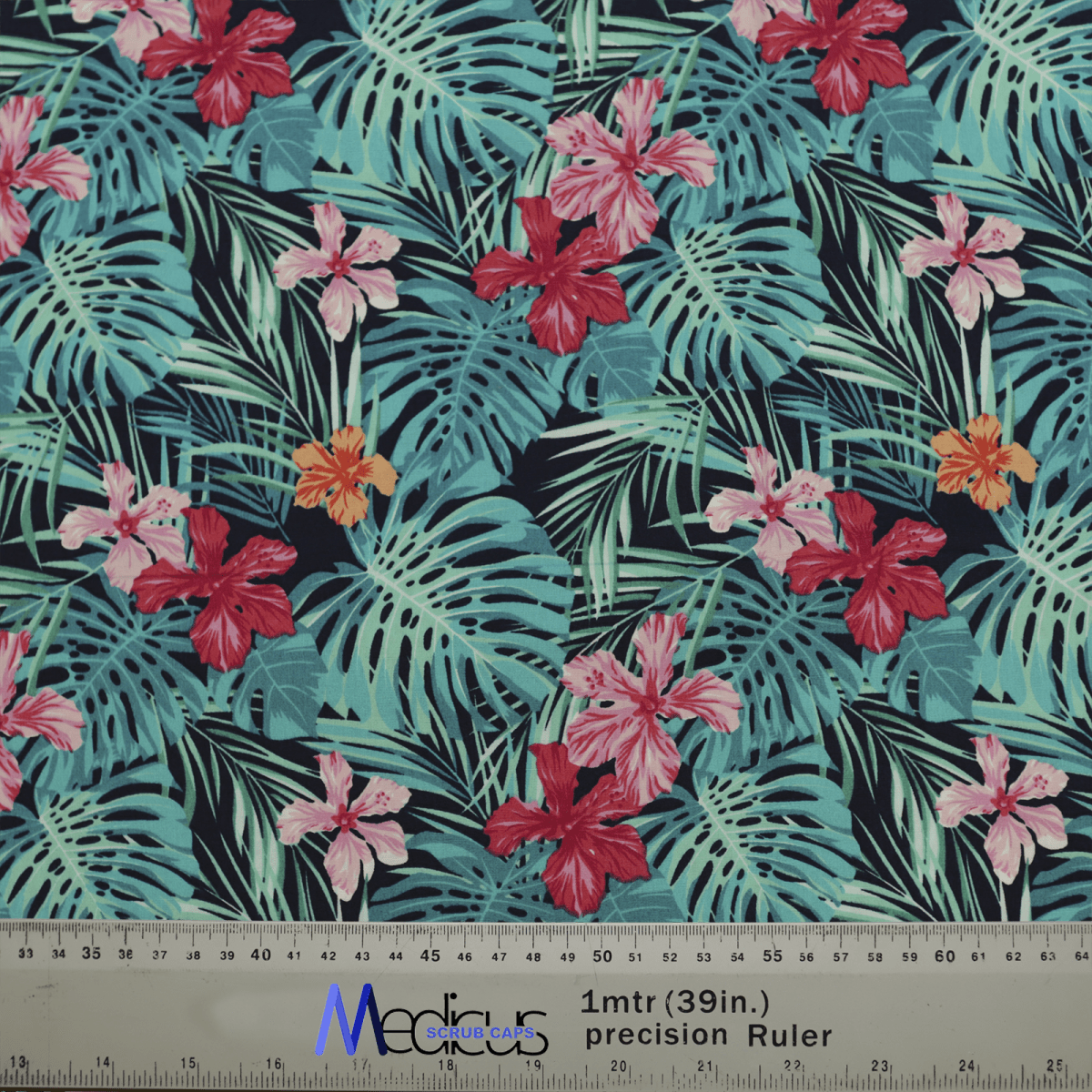 The Hawaiian Shirt Floral Palms Scrub Cap by Medicus Scrub Caps features vibrant hibiscus flowers and green palm leaves on a dark blue background. Ruler indicates size.