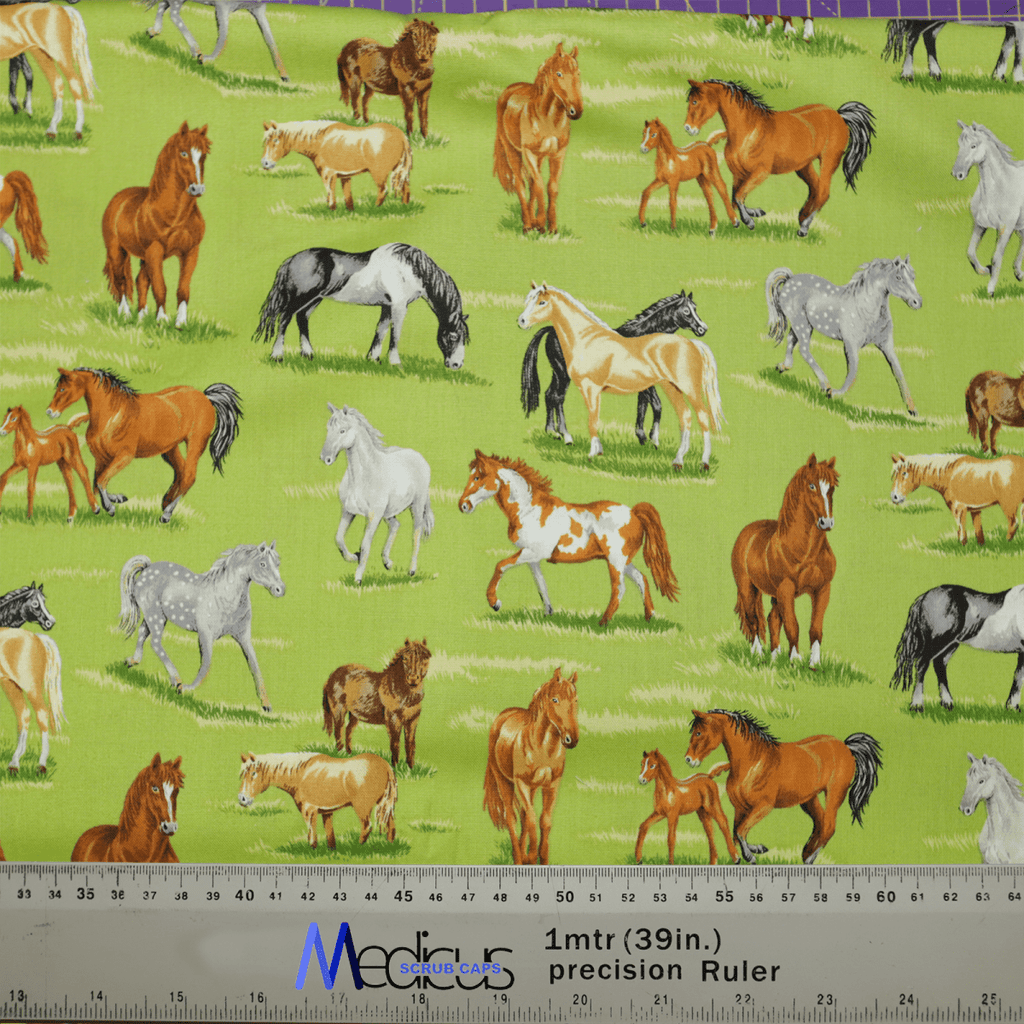 The Medicus Scrub Caps Horses In Field features a vibrant print of brown, white, and gray horses on a green background. Ideal for personalization, with galloping horses across grassy fields and a ruler for scale reference.