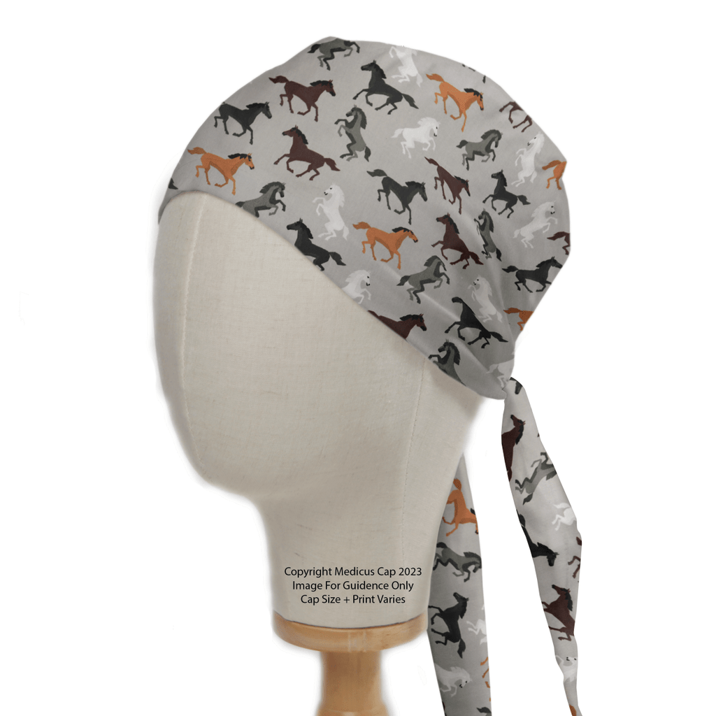 The Medicus Scrub Caps Horses On Grey Scrub Cap features a mannequin head displaying equestrian elegance, with a vibrant horse print on a light background and long ties at the back—perfect for healthcare professionals seeking stylish functionality.