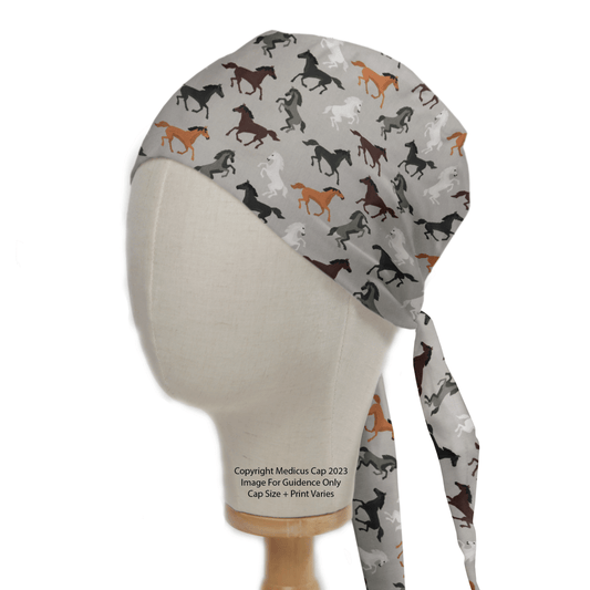 The Medicus Scrub Caps Horses On Grey Scrub Cap features a mannequin head displaying equestrian elegance, with a vibrant horse print on a light background and long ties at the back—perfect for healthcare professionals seeking stylish functionality.