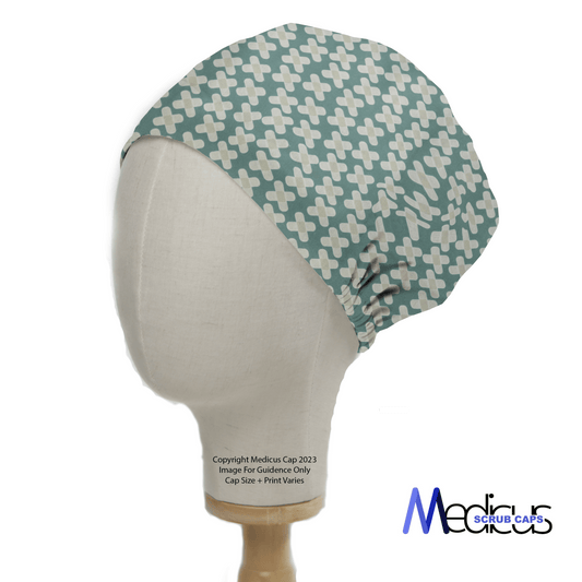 A mannequin head showcases the Hospital Plasters Scrub Cap with white and light blue plus signs on a green background, ideal for healthcare professionals. The elegant Medicus Scrub Caps logo is displayed at the bottom right.