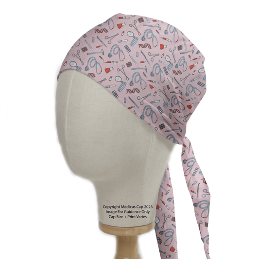 A mannequin head displays the Hospital Tools On Pink Scrub Cap by Medicus Scrub Caps, featuring a reusable pink design with medical tools like stethoscopes, syringes, scissors, and pills. Ideal for healthcare professionals, it includes long side ties.