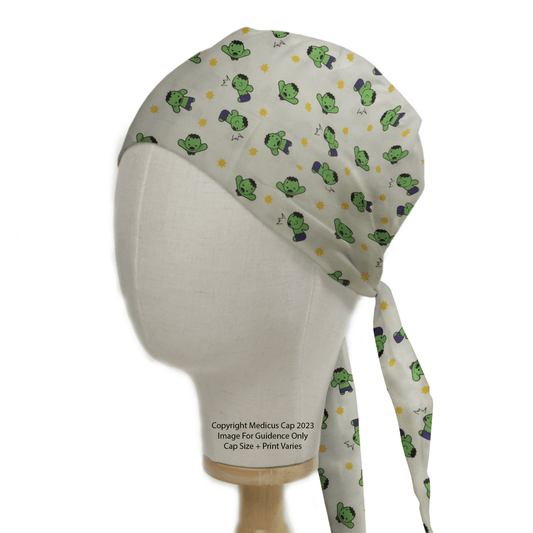 A white mannequin head models the Hulk Smash Kawaii Superhero Scrub Cap by Medicus Scrub Caps, featuring an adorable frog and flower design on a light background. This colorful, playful cap ties at the back and is perfect for fans of whimsical reusable scrub caps.