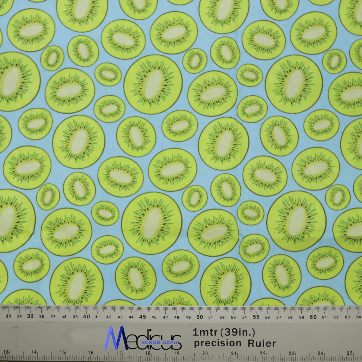 Introducing the Kiwi Scrub Cap by Medicus Scrub Caps, featuring a vibrant sliced kiwifruit design on light blue fabric. Its Medias ChaChaCAS ruler ensures a perfect fit, combining style and sustainability for your wardrobe.