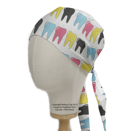 The mannequin head sports the Medicus Scrub Caps Large Colourful Teeth Scrub Cap, featuring vibrant tooth patterns in pink, blue, yellow, and black on white. This eco-friendly cap has handy ties at the back.