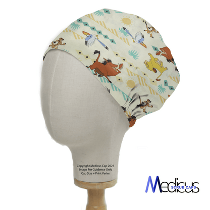 The Lion King Timone And Pumba Scrub Cap from Medicus Scrub Caps is showcased on a display head. It features playful animal and abstract patterns, colorful illustrations reminiscent of the Lion King, and the logo at the bottom, offering a comfortable fit against its light background.
