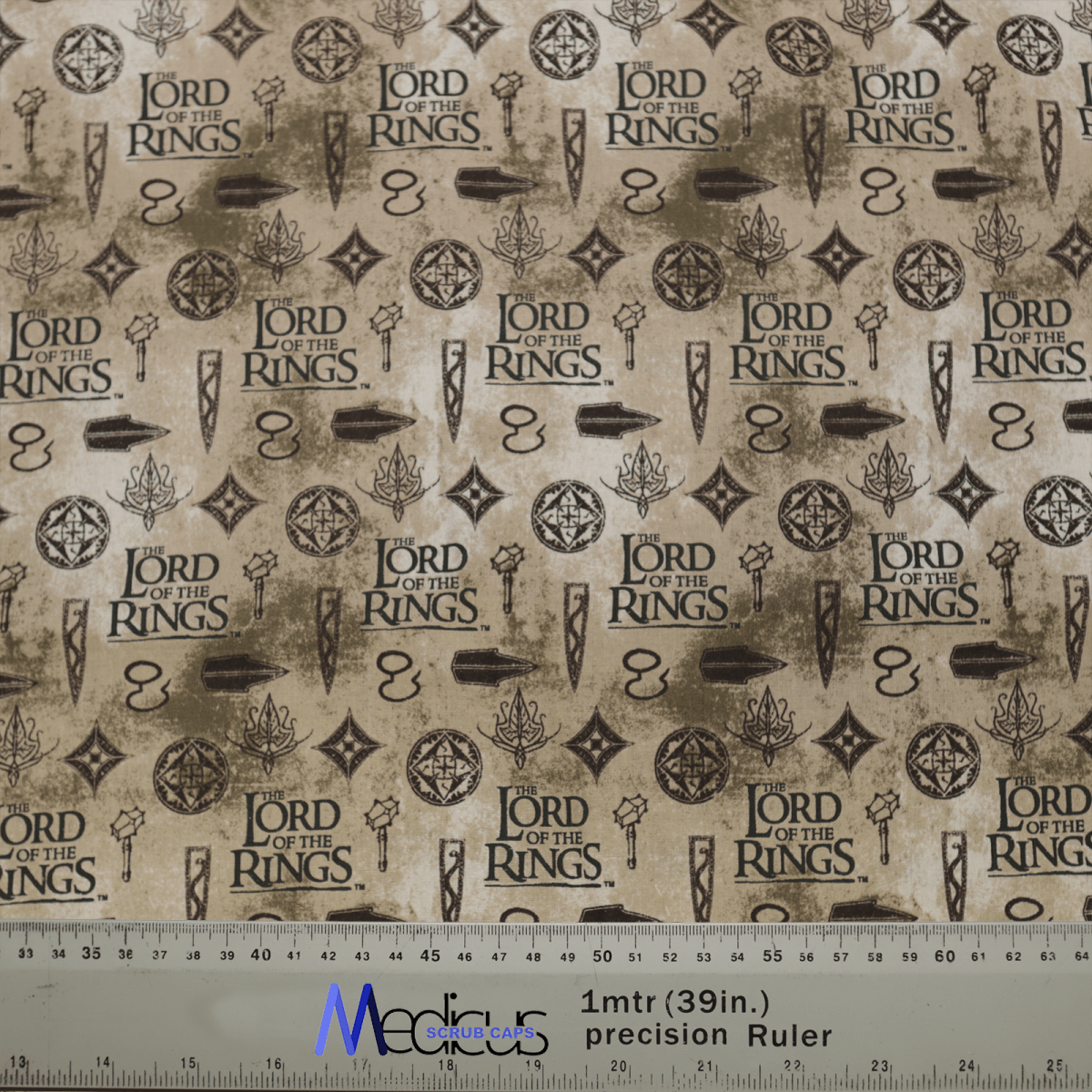 The Lord Of The Rings Titles Scrub Cap by Medicus Scrub Caps features eco-friendly fabric adorned with repeated Lord of the Rings logos, swords, rings, and mystical symbols on a beige background. A ruler at the bottom measures up to 1 meter or 39 inches in size.