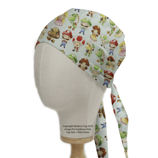 A mannequin head dons a Mario Kart Kawaii Characters Scrub Cap by Medicus Scrub Caps, featuring colorful cartoon characters like princesses, frogs, and bears. The cap ties at the back with playful dangling ends.