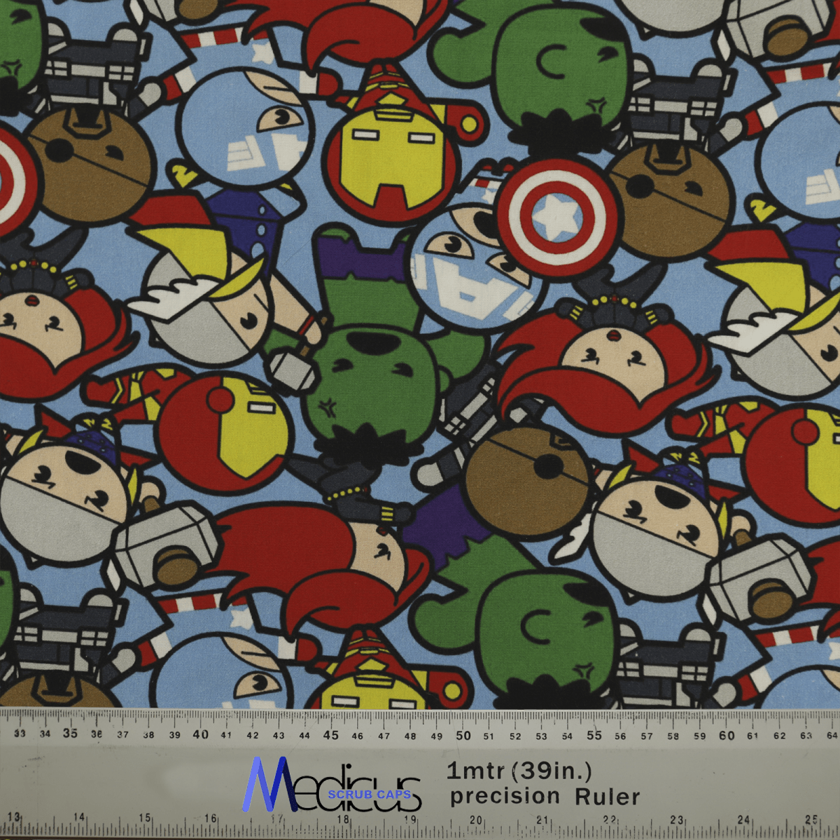 The Medicus Scrub Caps Marvel Avengers Cartoon Fighting Brawl fabric showcases superheroes in vivid red, blue, green, and yellow costumes. Ideal for crafting a scrub cap that adds heroic comfort to your healthcare gear. A ruler at the bottom measures approximately 1 meter.