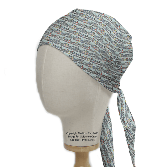 A mannequin head models the Medical Cabinet Pharmacy Scrub Cap by Medicus Scrub Caps, featuring a light blue and white design with colorful medical-themed icons on a plain white backdrop and elegantly draping ties at the back, capturing medical professionalism.