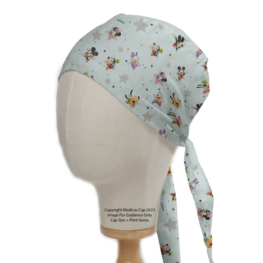 A mannequin head displays the Medicus Scrub Caps Mickey + Friends Blue Grey Stars, a custom-fit cap with a playful Disney print featuring Mickey and friends on a light blue backdrop with gray stars. This tie-back cap adds charm to medical and cosmetic attire.