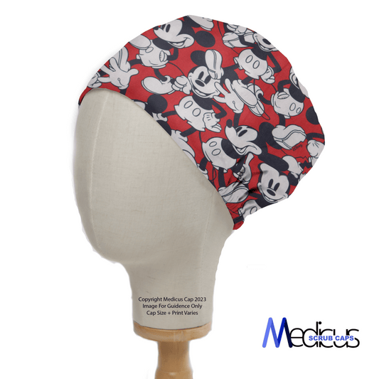 A mannequin features the popular Mickey On Red Scrub Cap by Medicus Scrub Caps, adorned with black, white, and red cartoon mouse faces showing playful expressions. Below reads: Copyright Medicus Cap 2023. Image for Guidance Only. Cap Size+Print Varies.