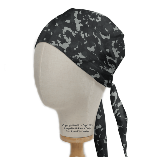 A mannequin head displays a durable Medicus Scrub Caps Military Camouflage Black Scrub Cap, showcasing a black and gray pattern with ties at the back.