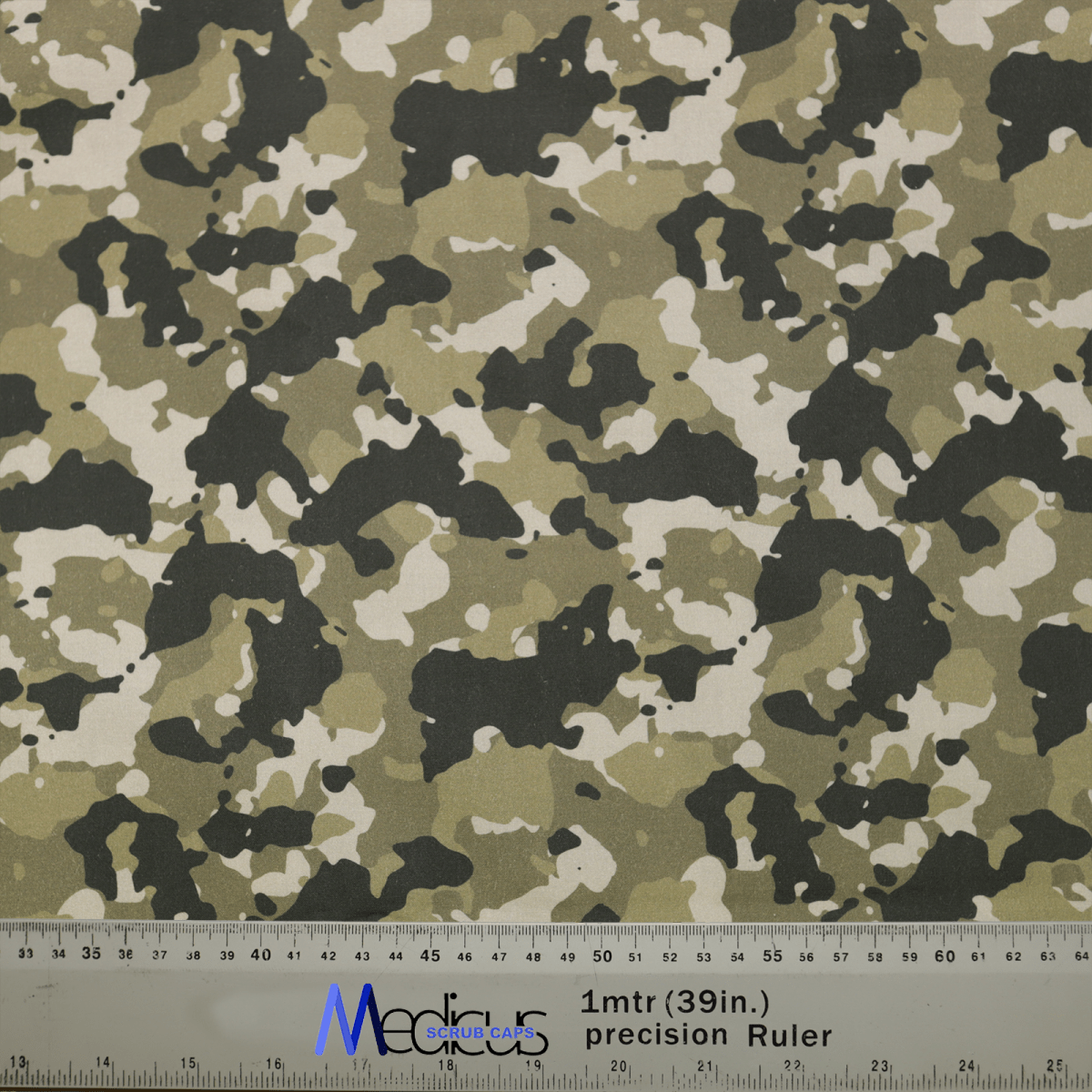 The Military Camouflage Desert Olive Green Scrub Cap by Medicus Scrub Caps features green, black, and white tones, ideal for healthcare professionals. A ruler with 1 mtr (39 in.) precision Ruler markings in cm and inches is partially visible alongside logos.