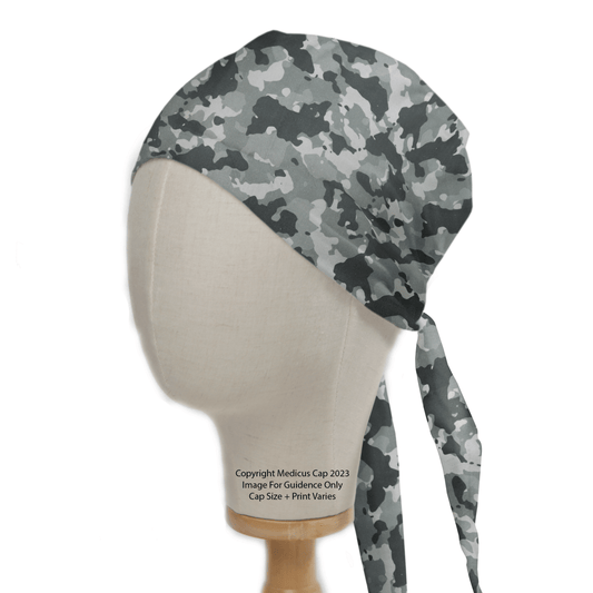 A mannequin head wears the Medicus Scrub Caps Military Camouflage Light Grey Scrub Cap, featuring a grey camo pattern with a tie-back bandana design.