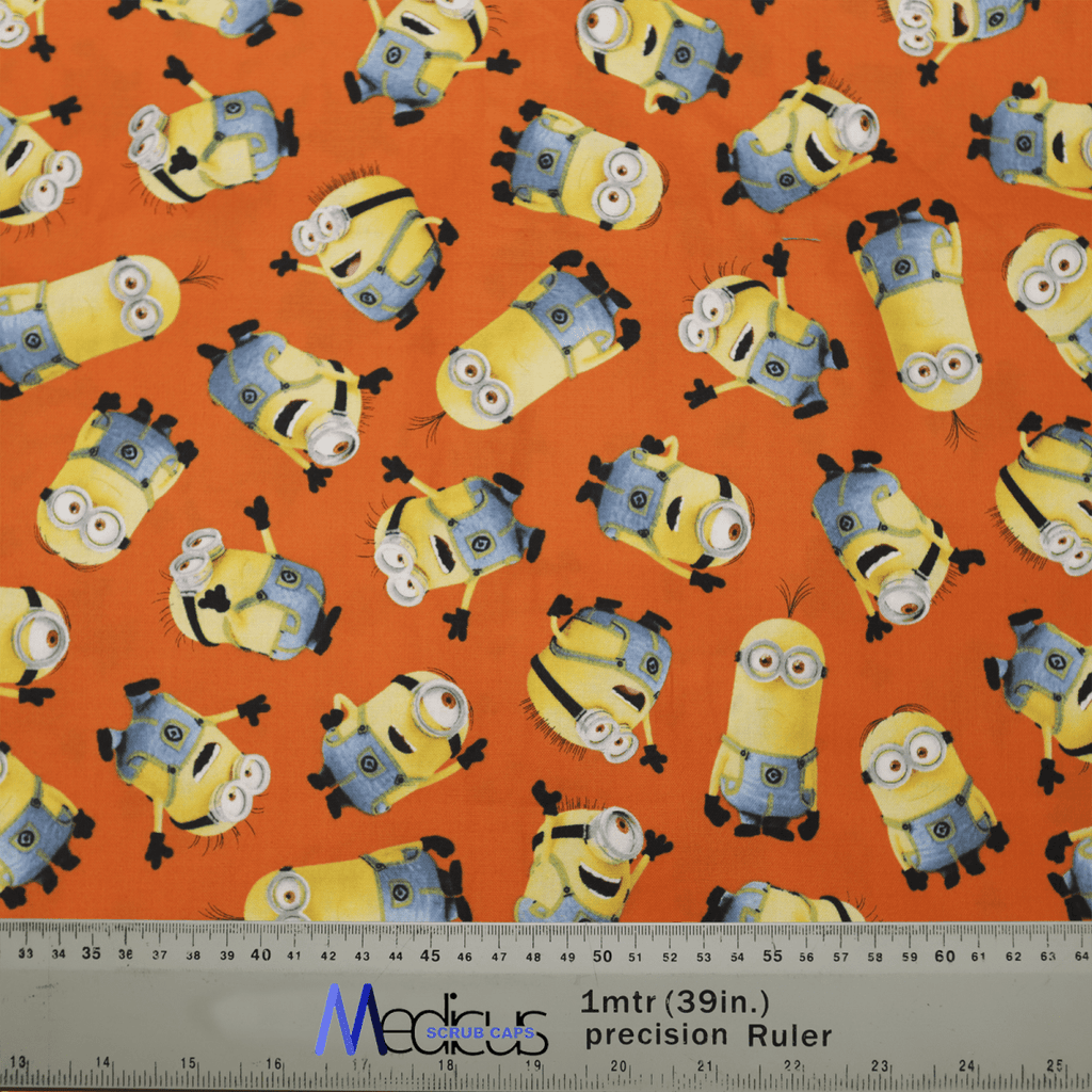 The Minions Orange Scrub Cap by Medicus Scrub Caps features a bright orange fabric with cartoon yellow creatures in blue overalls and goggles. Its comfortable, durable, eco-friendly, and includes a ruler displaying measurements in inches and centimeters.