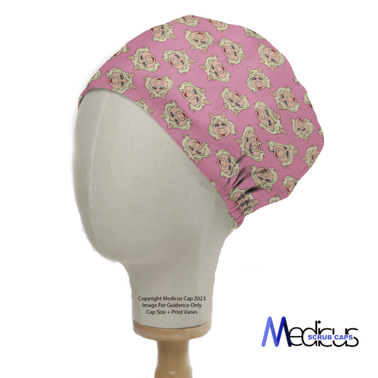 A mannequin head showcases the Muppets Miss Piggy Toss Scrub Cap by Medicus Scrub Caps, featuring a playful pug pattern and their logo in the bottom right corner, ideal for healthcare professionals.