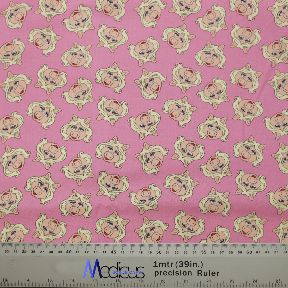 The Muppets Miss Piggy Toss Scrub Cap by Medicus Scrub Caps features a pink fabric with cartoon Miss Piggy sporting blonde hair and pearl earrings. Its perfect for healthcare professionals seeking style in the medical field, complete with a ruler for easy measurement.