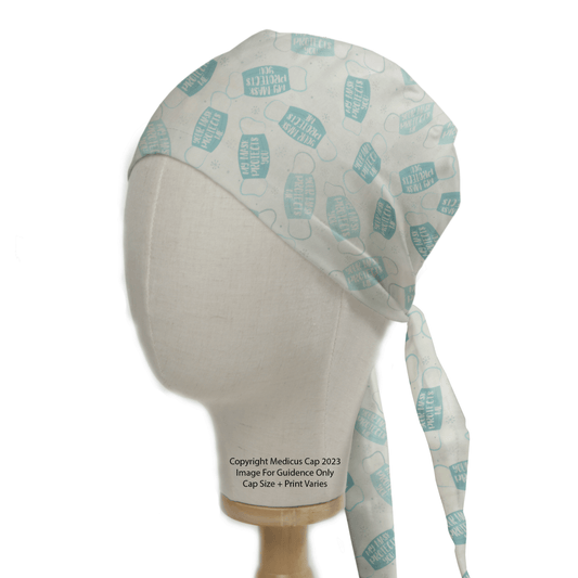 Head mannequin showcasing the eco-friendly My Mask Protects You scrub cap by Medicus Scrub Caps, featuring blue and teal medical-themed graphics. The cap ties at the back for comfort and fit, with text over the mannequins neck detailing image guidance and copyright information.