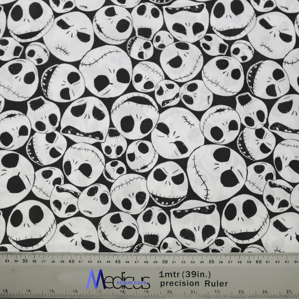 The Nightmare Before Christmas Skulls on White Scrub Cap by Medicus Scrub Caps features white skull illustrations with unique expressions on a black background and includes a ruler in centimeters and inches for scale, making it an eco-friendly choice.
