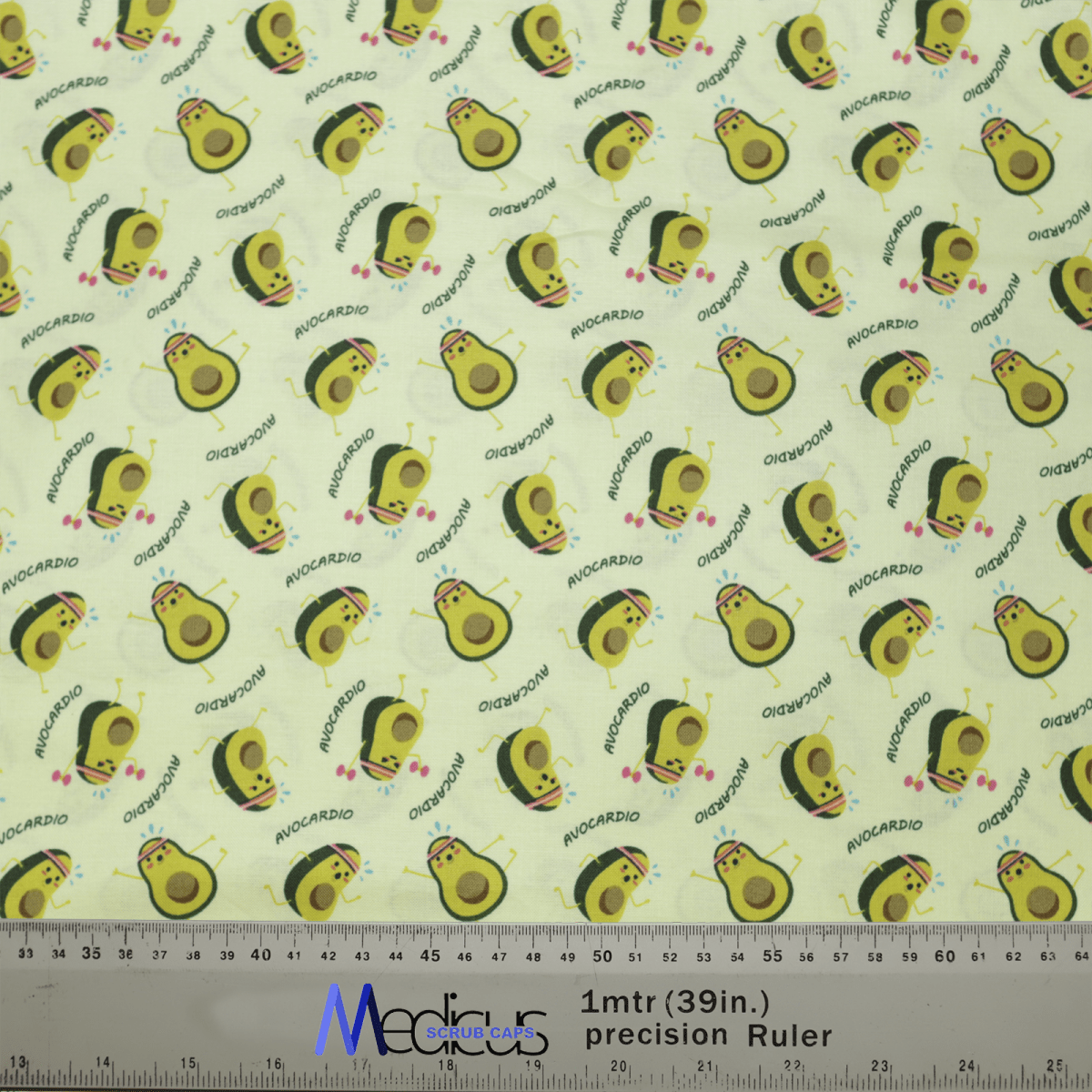 The Pun-tastic: Avo-cardio Scrub Cap by Medicus Scrub Caps features smiling avocados and AVOCARDIO on a light yellow background. Perfect for healthcare professionals, its eco-friendly with a ruler shown for scale.