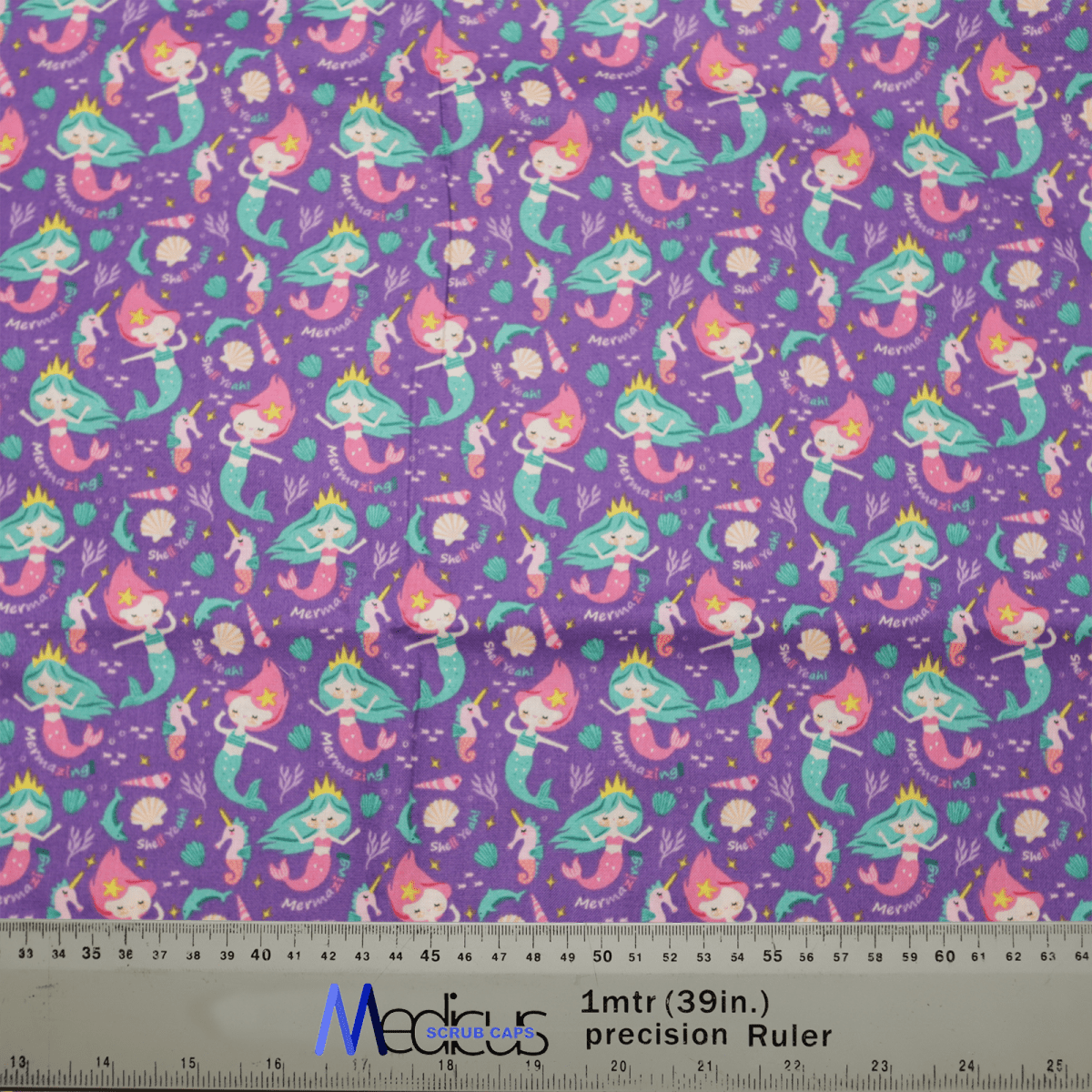 Introducing the eco-friendly Pun-tastic: Mermazing! Scrub Cap by Medicus Scrub Caps, featuring a purple fabric with vibrant mermaid illustrations, coral, shells, and seaweed. A handy ruler at the bottom offers measurement markings for added convenience and comfort.