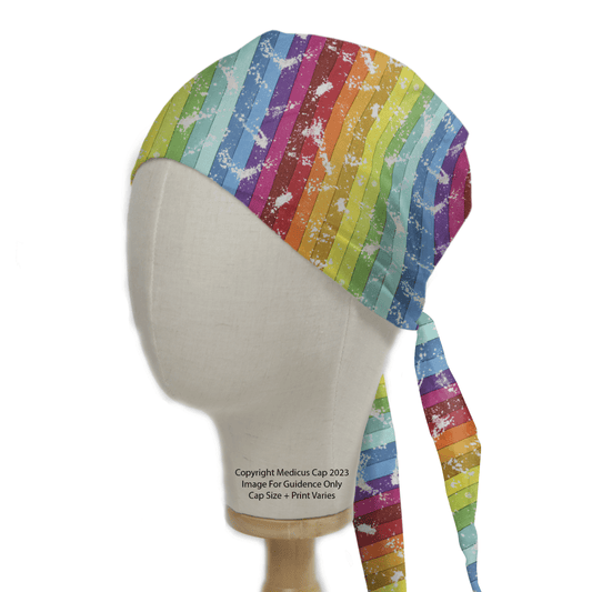 A mannequin head sports the Rainbow Graffiti Scrub Cap by Medicus Scrub Caps, featuring a vibrant, sustainable design with rainbow stripes and splatter patterns arranged diagonally.