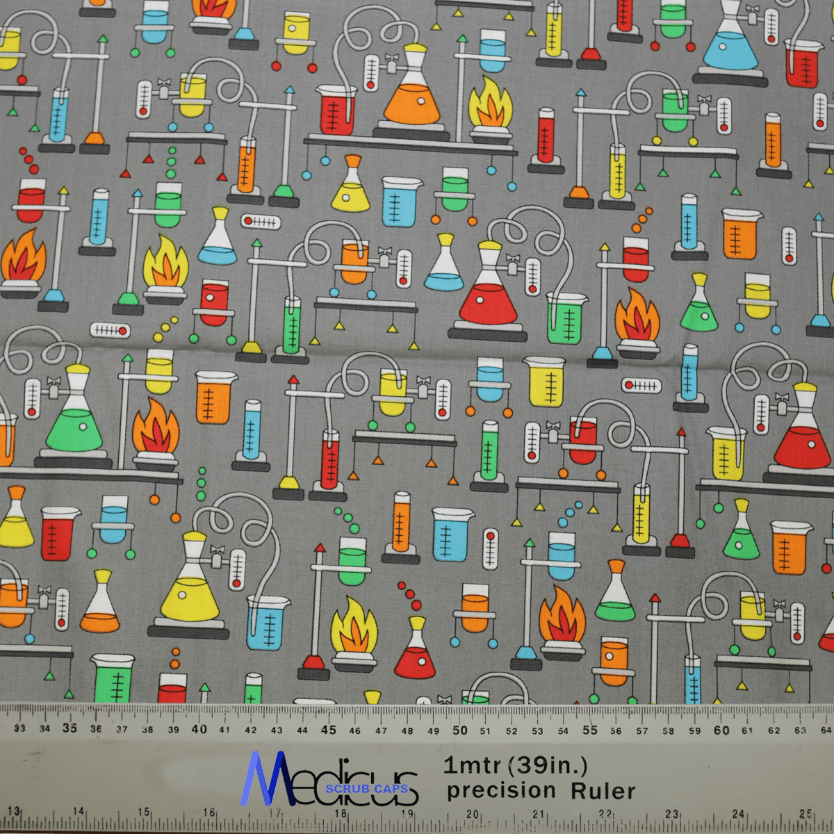 This eco-friendly Medicus Science Bunsen Burners Scrub Cap fabric features colorful lab equipment, such as beakers and flasks, on a gray background. It includes a ruler for scale, measuring one meter or 39 inches. Perfect for a scrub hat!.