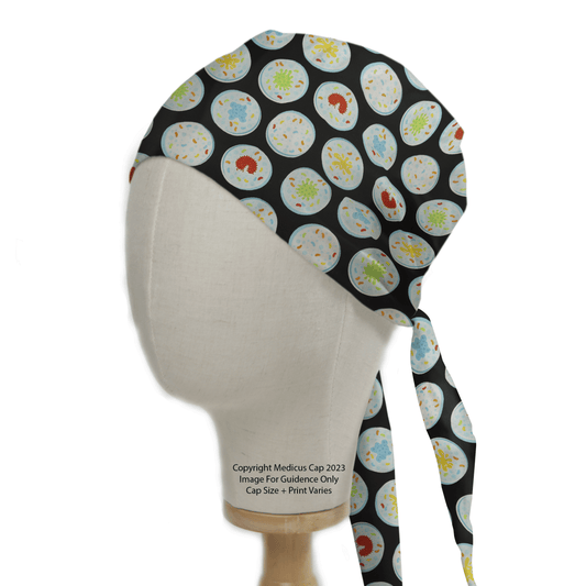 The mannequin head showcases the Medicus Scrub Caps Science Epidemic Petri Dishes Scrub Cap, featuring colorful petri dish patterns on a black background. Ideal for healthcare professionals, it includes long ties for a secure fit.