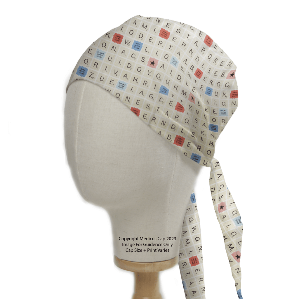 The Medicus Scrub Caps Scrabble Board Classic Vintage Scrub Cap features a crossword puzzle design with letter tiles and blue and red star illustrations, complete with long ties, perfect for word enthusiasts.