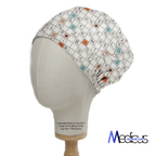 A mannequin displays the Medicus Scrub Caps Scrabble Board Scrub Cap, merging playful professionalism with a crossword design of letters and numbers. It features orange and blue squares for a comfortable fit, branded in the bottom right corner.
