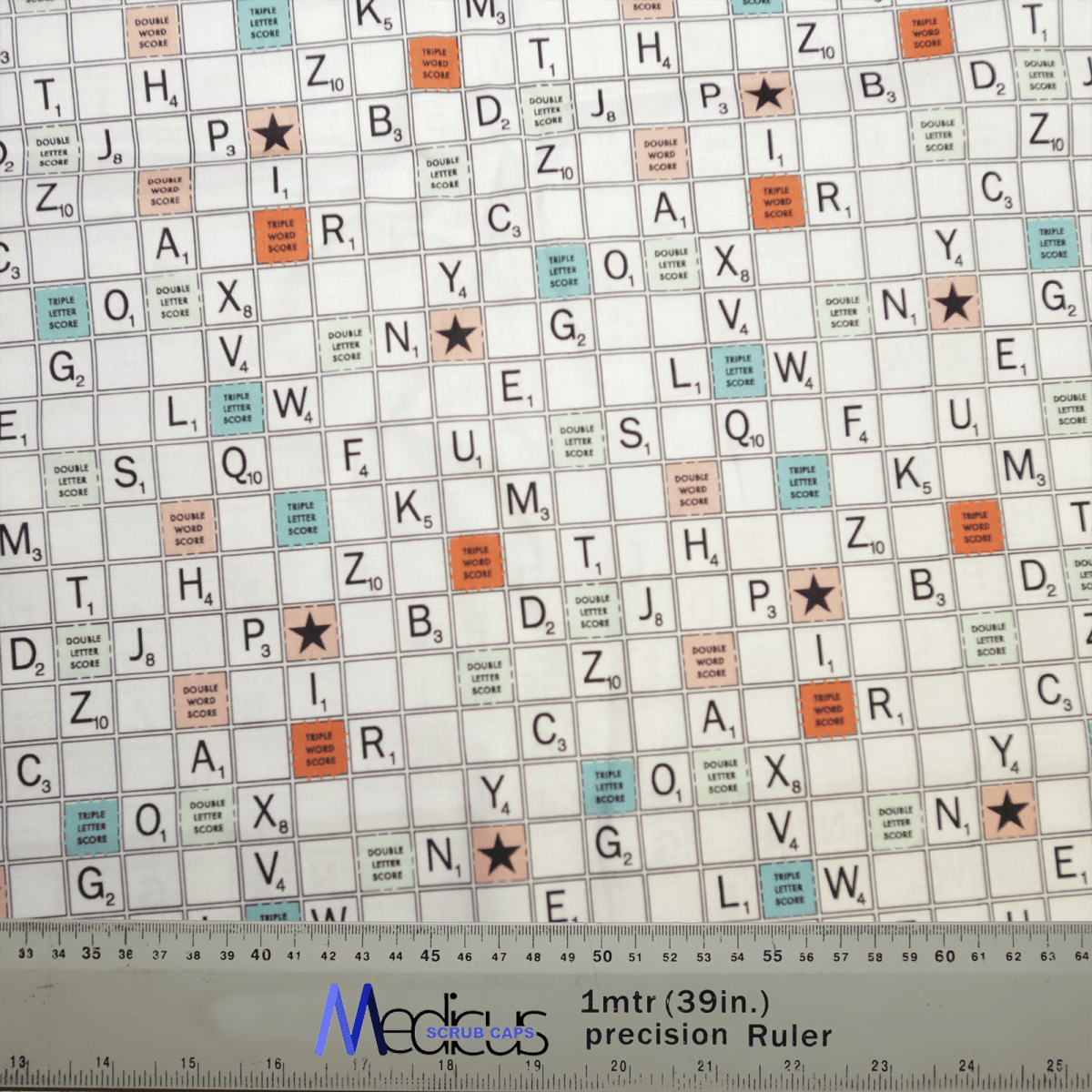 An image shows a Scrabble board pattern with various letters and special scoring squares. At the bottom, a 1mtr (39in) precision Ruler with a logo is present, reminiscent of professional style for those embracing the Medicus Scrub Caps Scrabble Board Scrub Cap look.