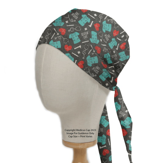 A mannequin head displays the Medicus Scrub Caps Scrub Life scrub cap on a black background with medical-themed illustrations, such as teal anatomical and red heart designs. Ideal for healthcare professionals, it ties at the back, with partial text visible near the base.