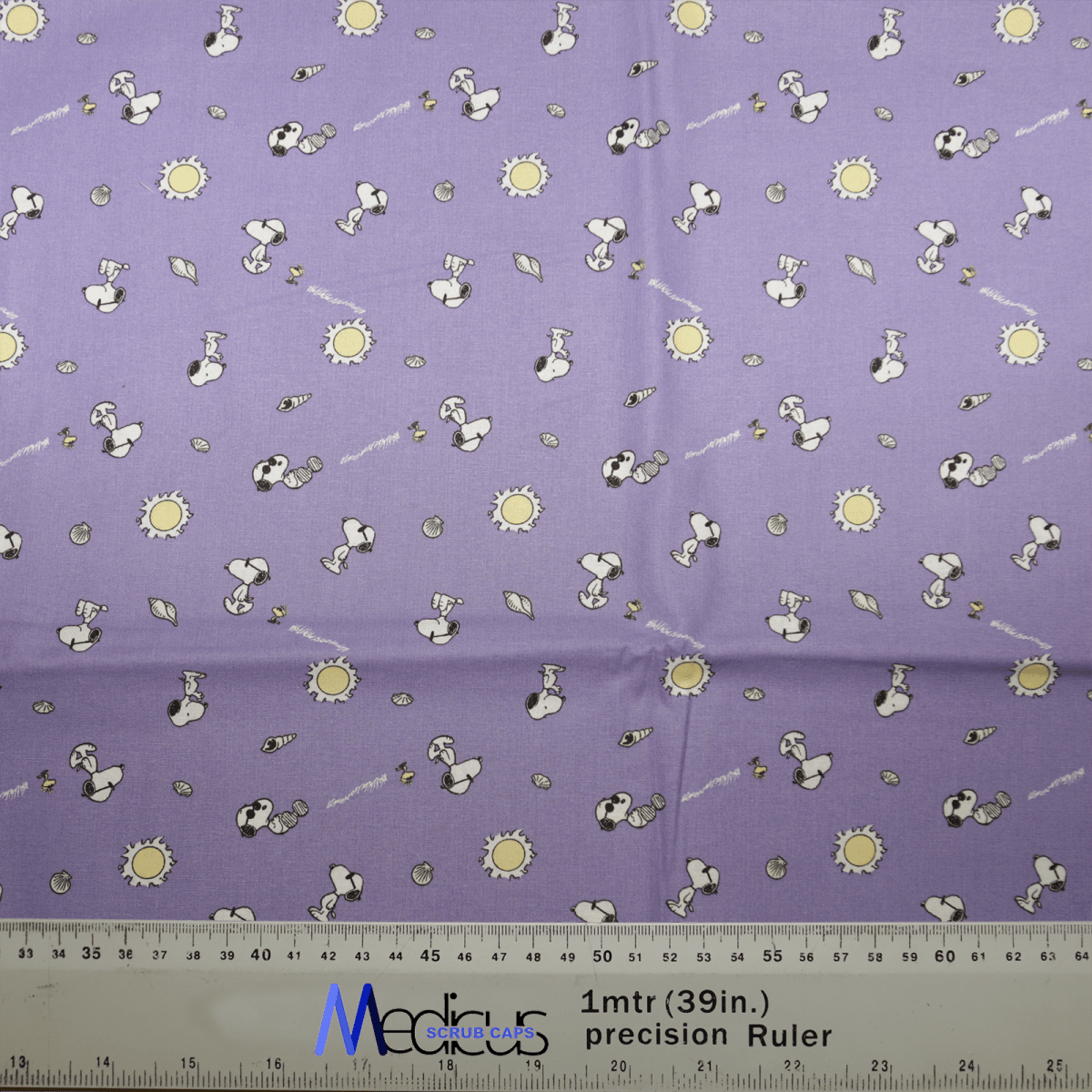 The Snoopy Purple Sunshine Friends Scrub Cap by Medicus Scrub Caps features a whimsical design of goggle-wearing Snoopy with yellow suns and gray circles on a purple background. Its perfect for crafting playful scrub caps, with a ruler at the bottom aiding sustainable healthcare practices through precise measuring.