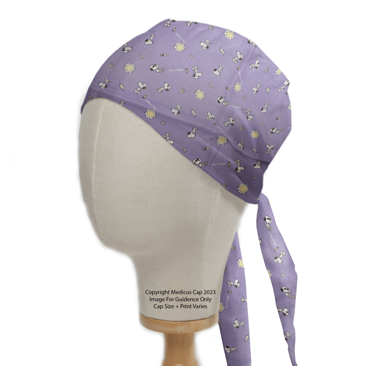 A mannequin displays the Snoopy Purple Sunshine Friends Scrub Cap by Medicus Scrub Caps, featuring cartoon dogs and yellow suns with fabric ties at the back. Text states, Copyright Medicos Cap 2023. Image for guidance only. Cap size and print vary.