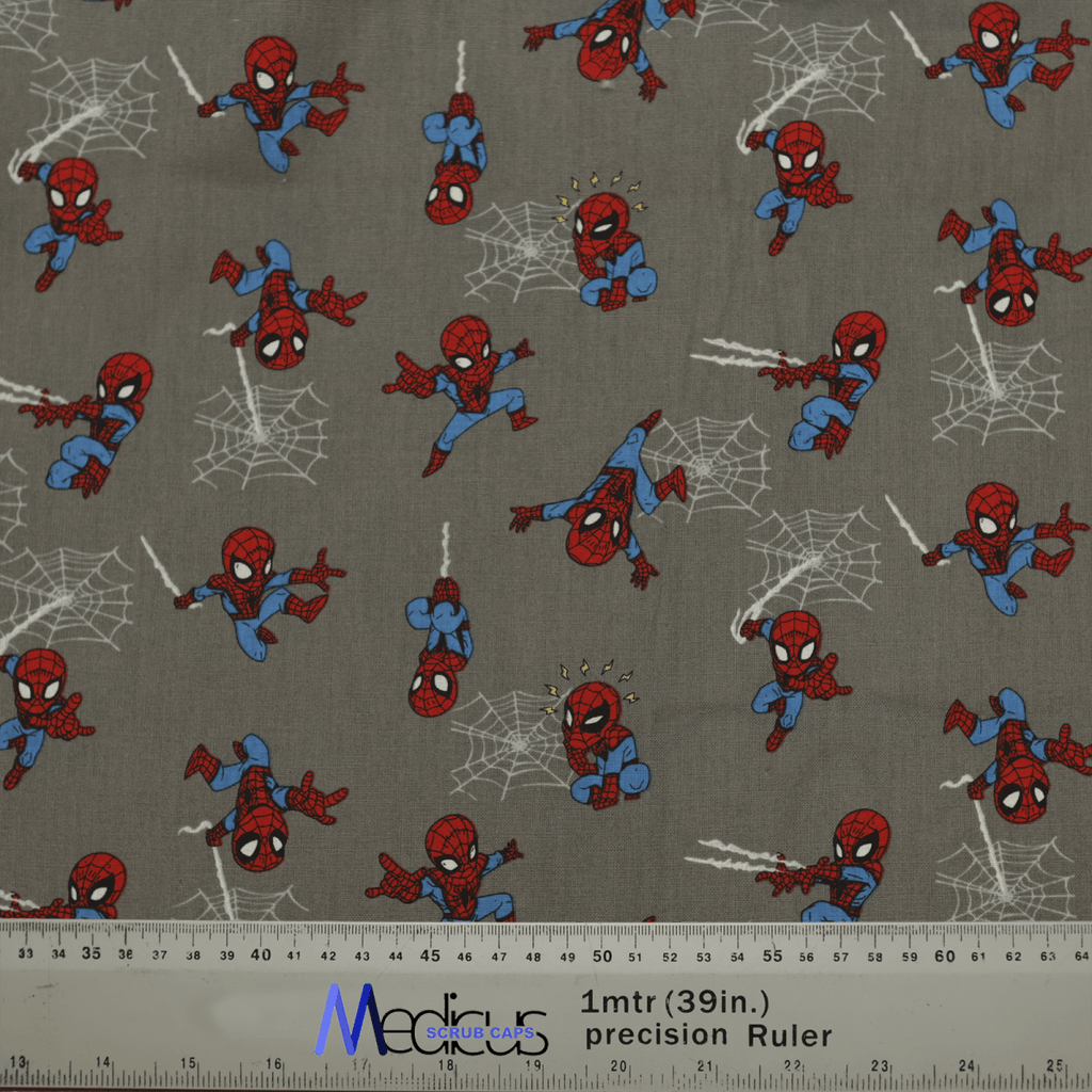 The Spiderman Kawaii On Grey Scrub Cap by Medicus Scrub Caps features small red and blue superhero illustrations swinging on a gray background. A ruler at the bottom shows length in inches and centimeters, ensuring an exceptional fit and comfort for healthcare professionals.
