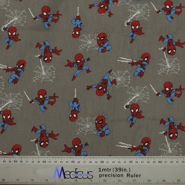The Spiderman Kawaii On Grey Scrub Cap by Medicus Scrub Caps features small red and blue superhero illustrations swinging on a gray background. A ruler at the bottom shows length in inches and centimeters, ensuring an exceptional fit and comfort for healthcare professionals.